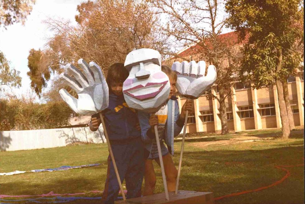 two kids are playing with the puppet head and hands they built