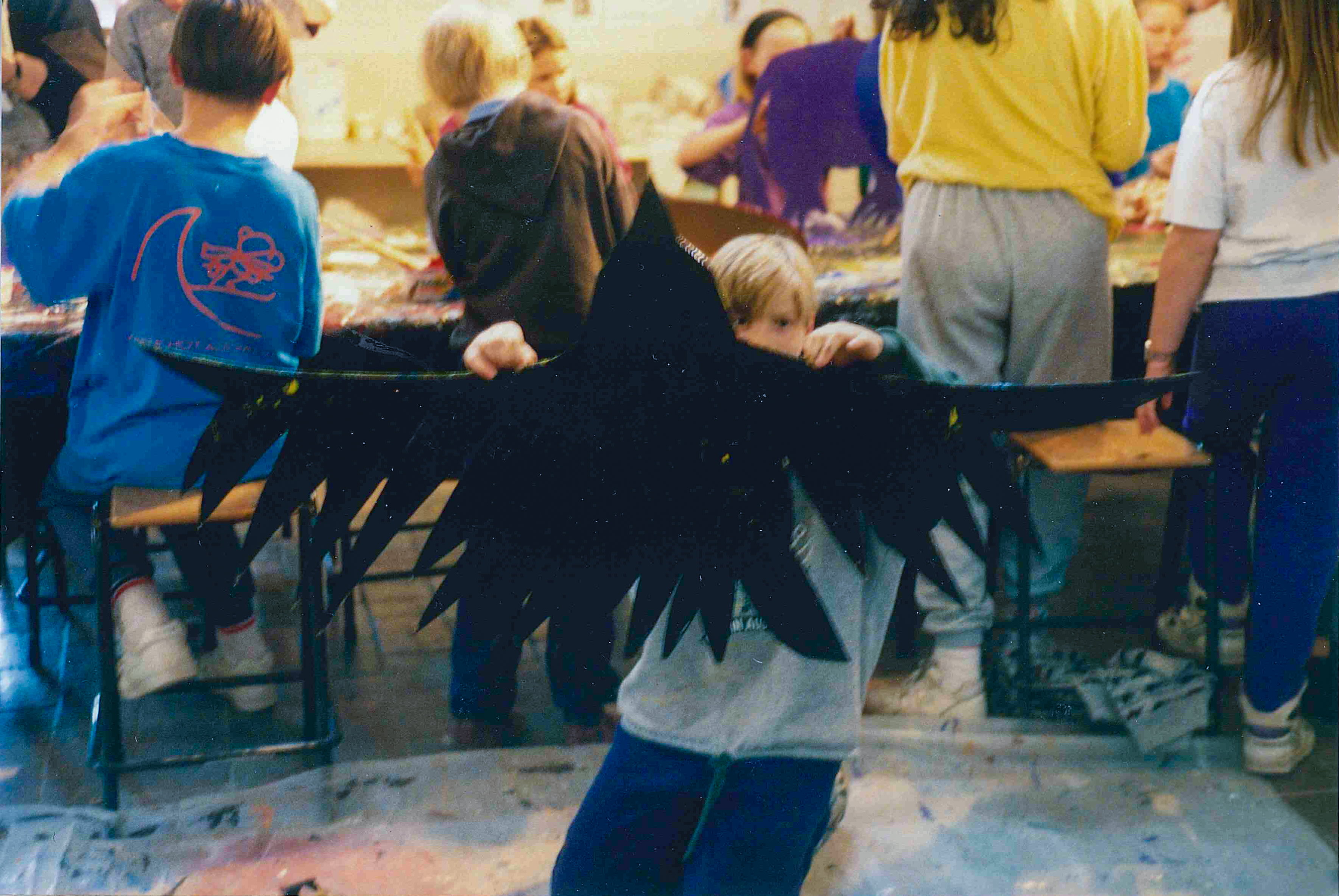 A young boy is holding up a cutout bird