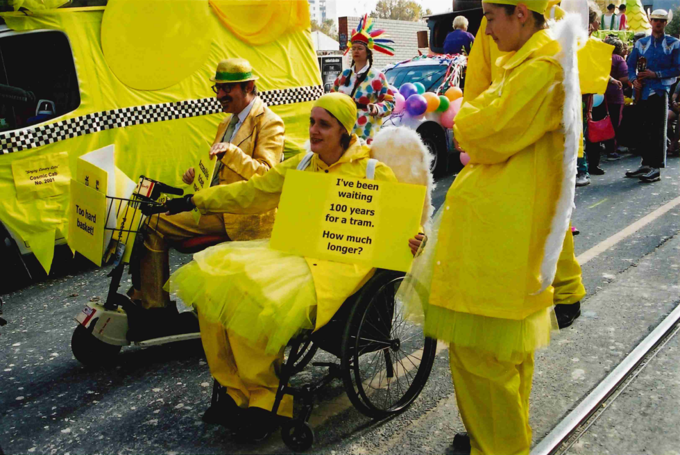 people in wheelchairs are riding down the street with signs saying 