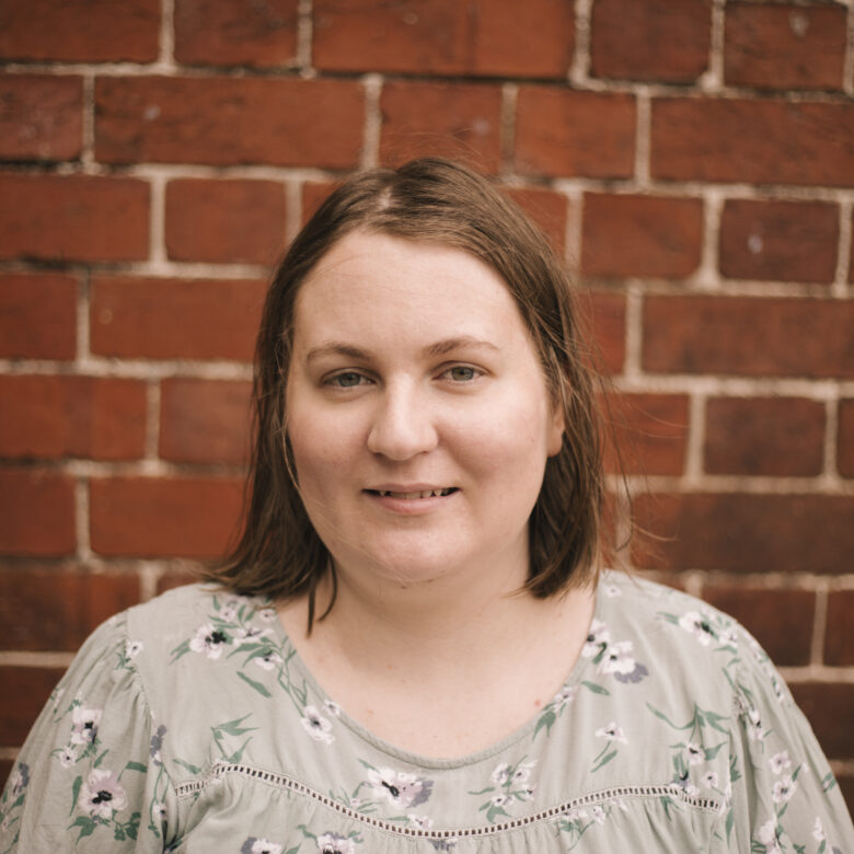 A headshot of Megan Williams in front of a brick wall