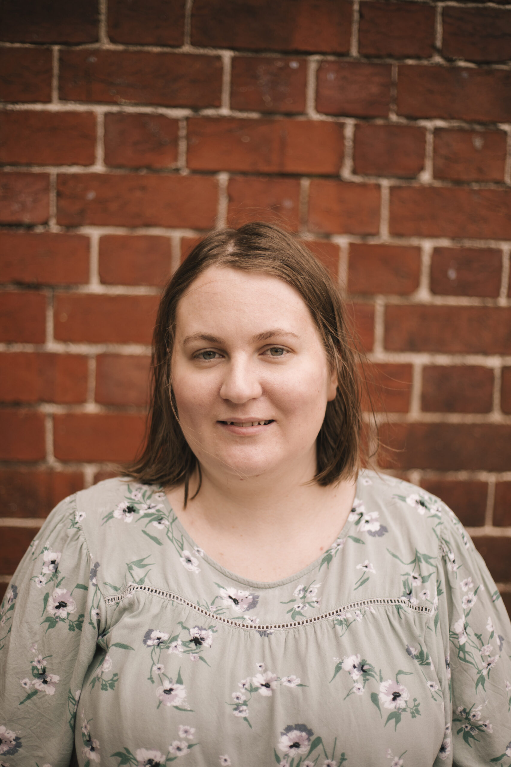 A headshot of Megan Williams in front of a brick wall