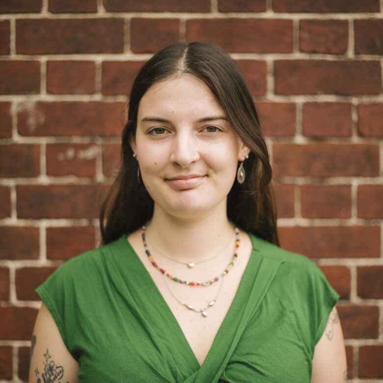 A headshot of Nina Fitzsimmons in front of brick wall