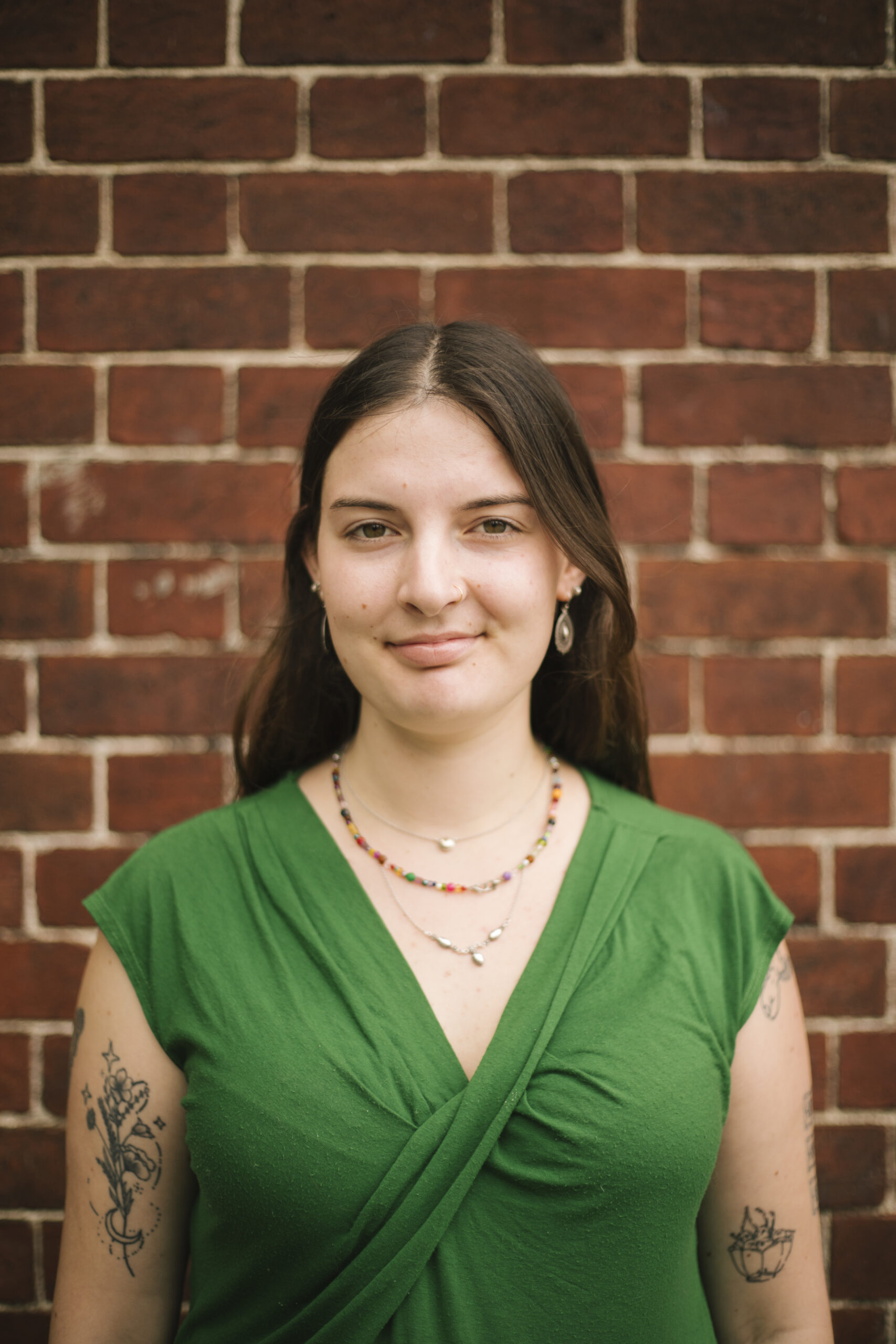 A headshot of Nina Fitzsimmons in front of brick wall