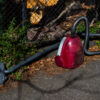 a red vacuum cleaner sitting on the footpath